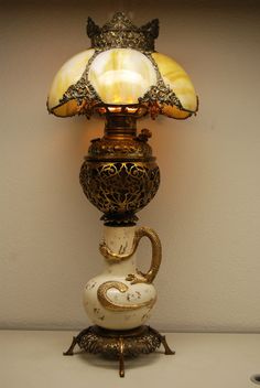 a lamp that is sitting on top of a table in front of a white wall