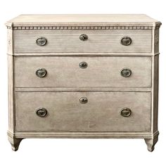 an antique chest of drawers with four drawers and two pulls on each drawer, all in white