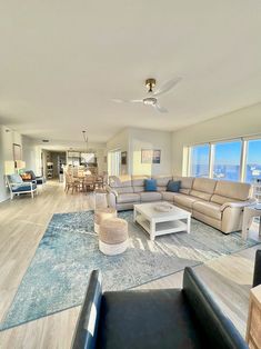 a living room filled with furniture and large windows