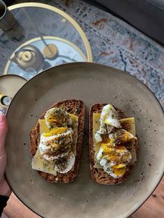 someone holding a plate with two pieces of bread on it