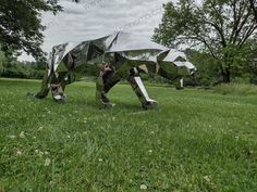 an animal made out of metal in the grass