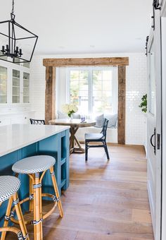 a kitchen with blue cabinets and stools