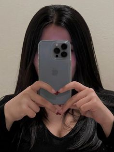 a woman taking a selfie in front of her cell phone with the camera attached