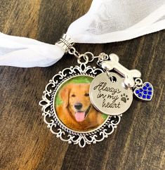 a dog's photo on a keychain with a white ribbon around it