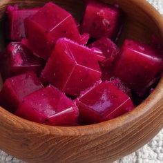 a wooden bowl filled with cubed beets on top of a table