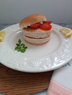 a sandwich on a plate with lemon wedges