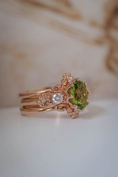 two gold rings with green and white stones