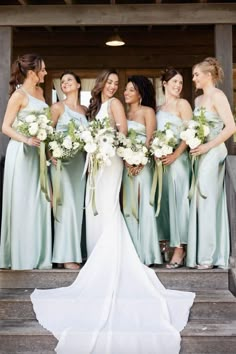 the bride and her bridesmaids are all dressed in mint green dresses with matching bouquets