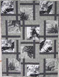 a black and white quilt with leaves on it