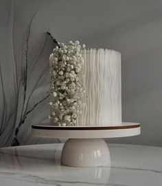 a three tiered cake with white icing and baby's breath flowers on top