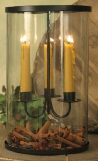 two yellow candles are in a glass container