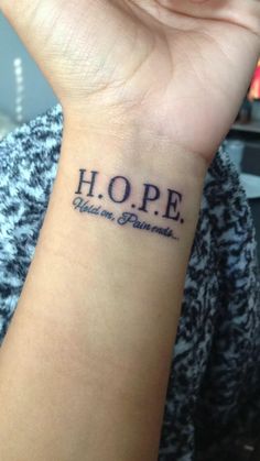 a woman's wrist tattoo with the word hope written on her left arm and an inscription that reads hope