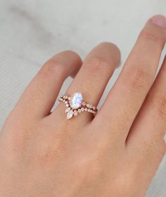 a woman's hand wearing a ring with an opal and diamonds on it