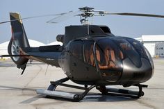 a black helicopter sitting on top of an airport tarmac