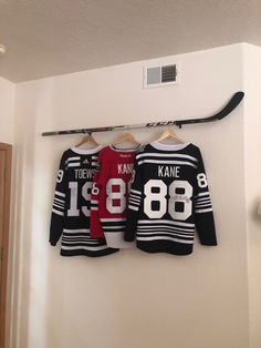 two hockey jerseys are hanging on the wall