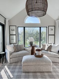 a living room filled with furniture and a large window covered in sunlight shining through the windows