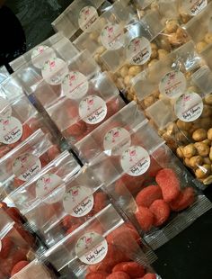 several plastic containers filled with different types of candies and nuts on display in a store