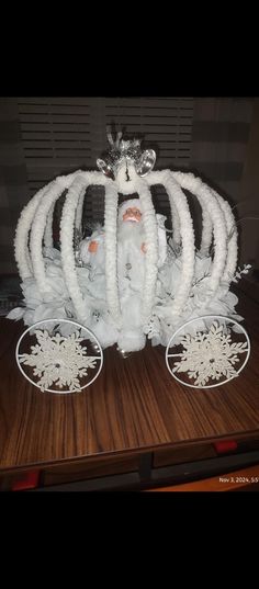 a white horse drawn carriage on top of a wooden table