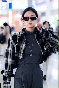 a woman in black and white checkered jacket with sunglasses