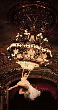 a ballerina is suspended from a chandelier