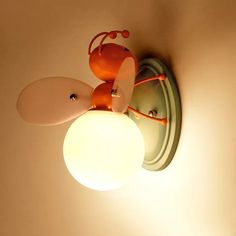 a lamp that is on the wall next to a light fixture with an animal design