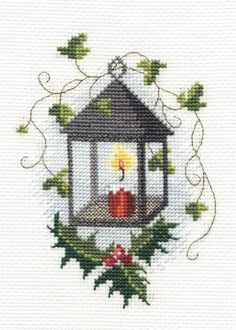 a cross stitched picture of a candle in a birdcage with holly on it