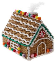 a crocheted gingerbread house ornament on a white background