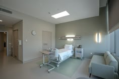 an empty hospital room with a bed and couch