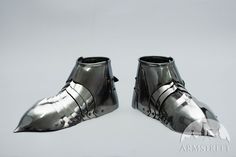 two silver shoes are sitting on top of each other, one is made out of metal