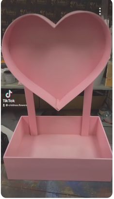 a pink heart shaped box sitting on top of a table