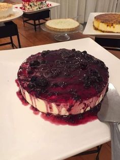 a cake sitting on top of a white plate covered in blueberries