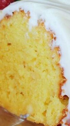 a close up of a piece of cake with icing and strawberries on the side