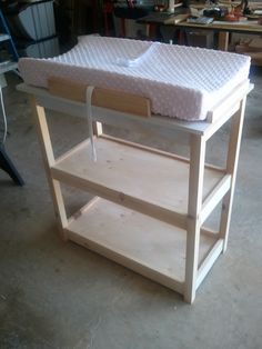 a baby changing table with a mattress on top