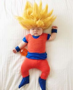 a baby in a costume laying on top of a white bed with his head up