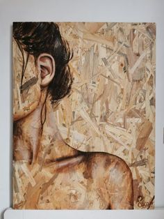 a painting of a woman's head and ear with wood shavings on the wall