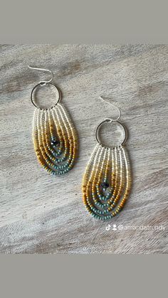 two pairs of beaded earrings on top of a wooden table