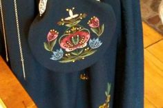 a blue shirt with flowers on it hanging from a rack