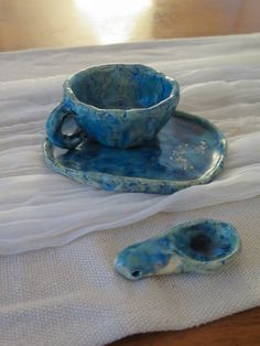 a tea cup and saucer sitting on top of a bed