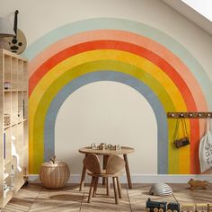 a child's room with a rainbow painted on the wall and toys in the floor