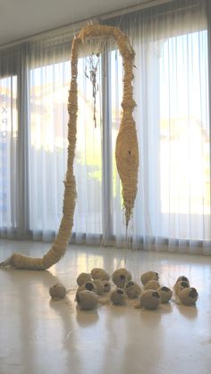 a sculpture made out of rope and balls on the floor