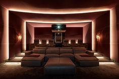 an empty theater room with couches and lights