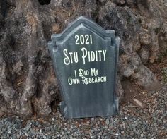 a grave marker sitting in front of a tree with the words, sit dirty i did my own research written on it