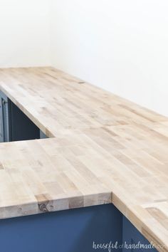 a wooden counter top in a kitchen with blue cabinets