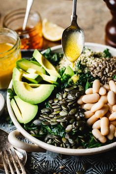 a bowl filled with beans, avocado, and other foods on top of a table