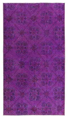 a purple rug with an intricate design on the top and bottom corner, in different colors