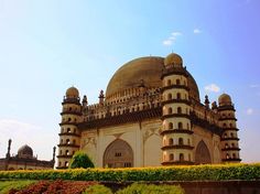 a large building with many windows and domes on it's sides in the middle of a park