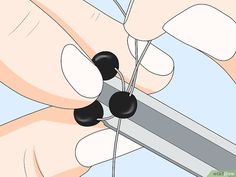 an image of someone cutting black beads with scissors