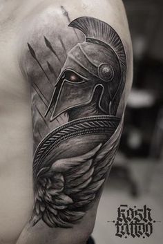 a man's arm with a spartan helmet on it and an arrow in the middle