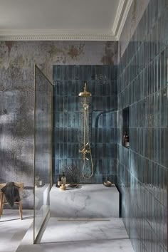 a bath room with a stand up shower next to a chair and a mirror on the wall