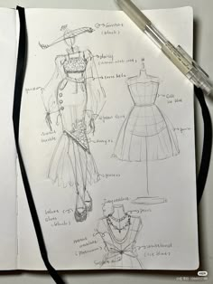 an open notebook with sketches of dresses on it